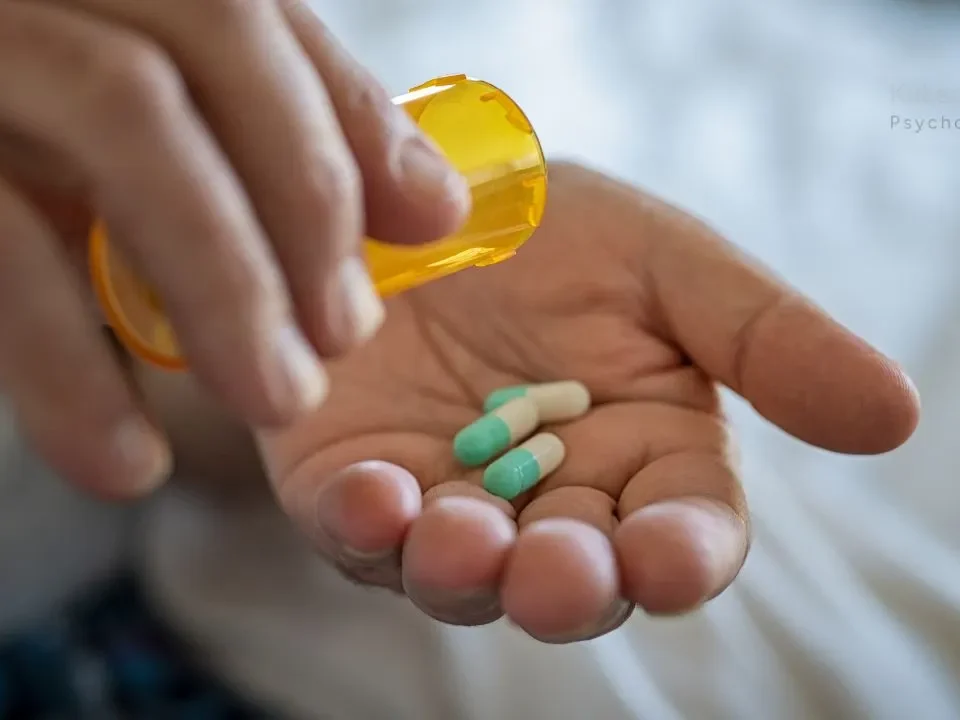 Wpływ antydepresantów na osobowość: Osoba dawkuje dwie pigułki leku na rękę z żółtego pojemnika