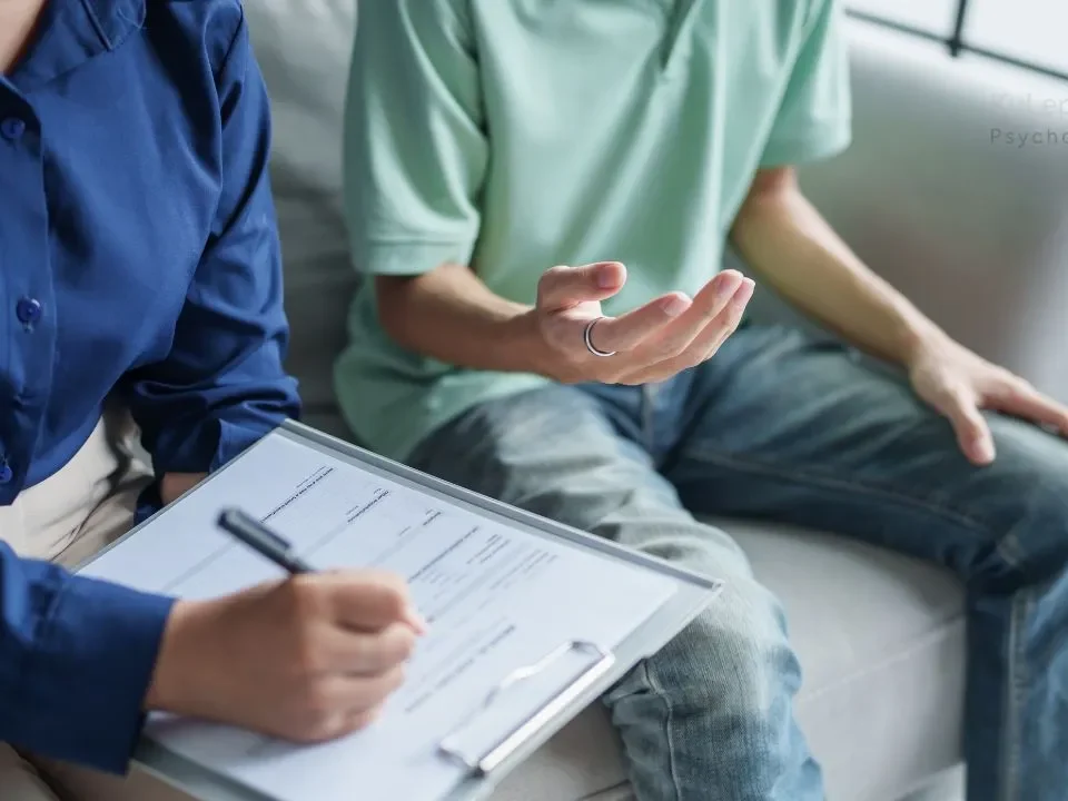skala depresji Hamiltona: Kobieta wypełnia formularz, a mężczyzna gestykuluje dłońmi podczas sesji psychoterapii.